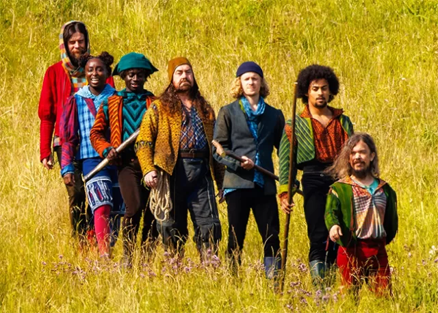 seven intersectional and sloppily dressed characters from 2025's snow white stand in a field