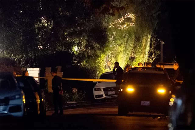 "Police officers and crime scene tape outside Rob Reiner's Brentwood home at night following the discovery of the director and his wife Michele Singer Reiner found dead on December 14, 2025, with emergency vehicles and yellow tape blocking the upscale Los Angeles street